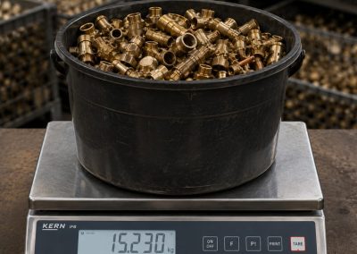 Pesée de laiton en centre de rachat de métaux dans l’Ouest Lyonnais avec balance